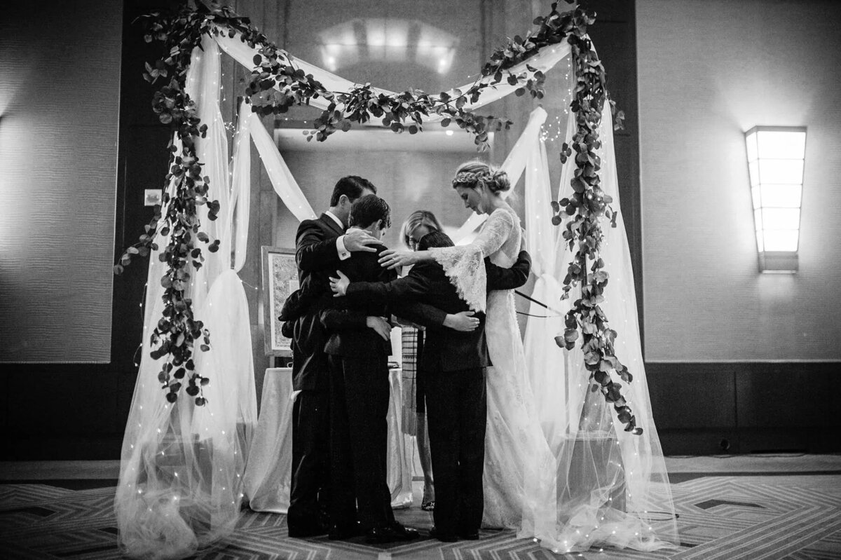 A group of people huddled together during a wedding ceremony.