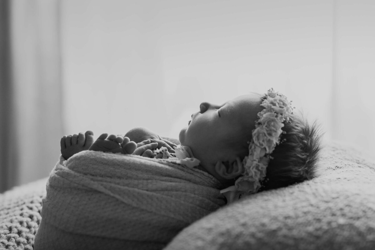 black and white fine art of a swaddled newborn wearing a flower crown