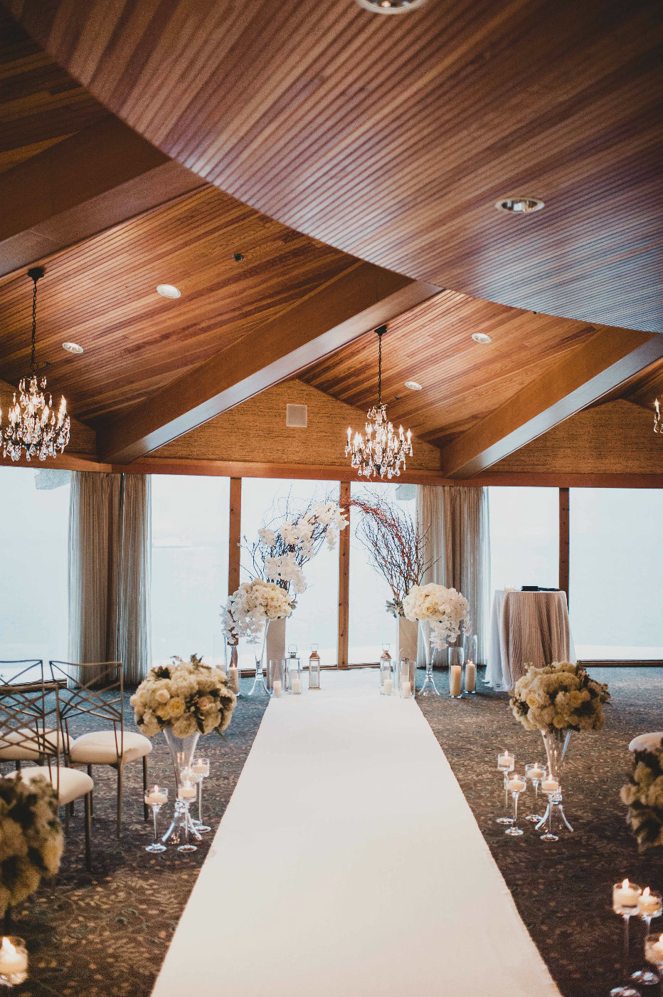 Romantic winter wedding ceremony setup with white orchid and willow branch arch designed by Flora Nova Seattle.