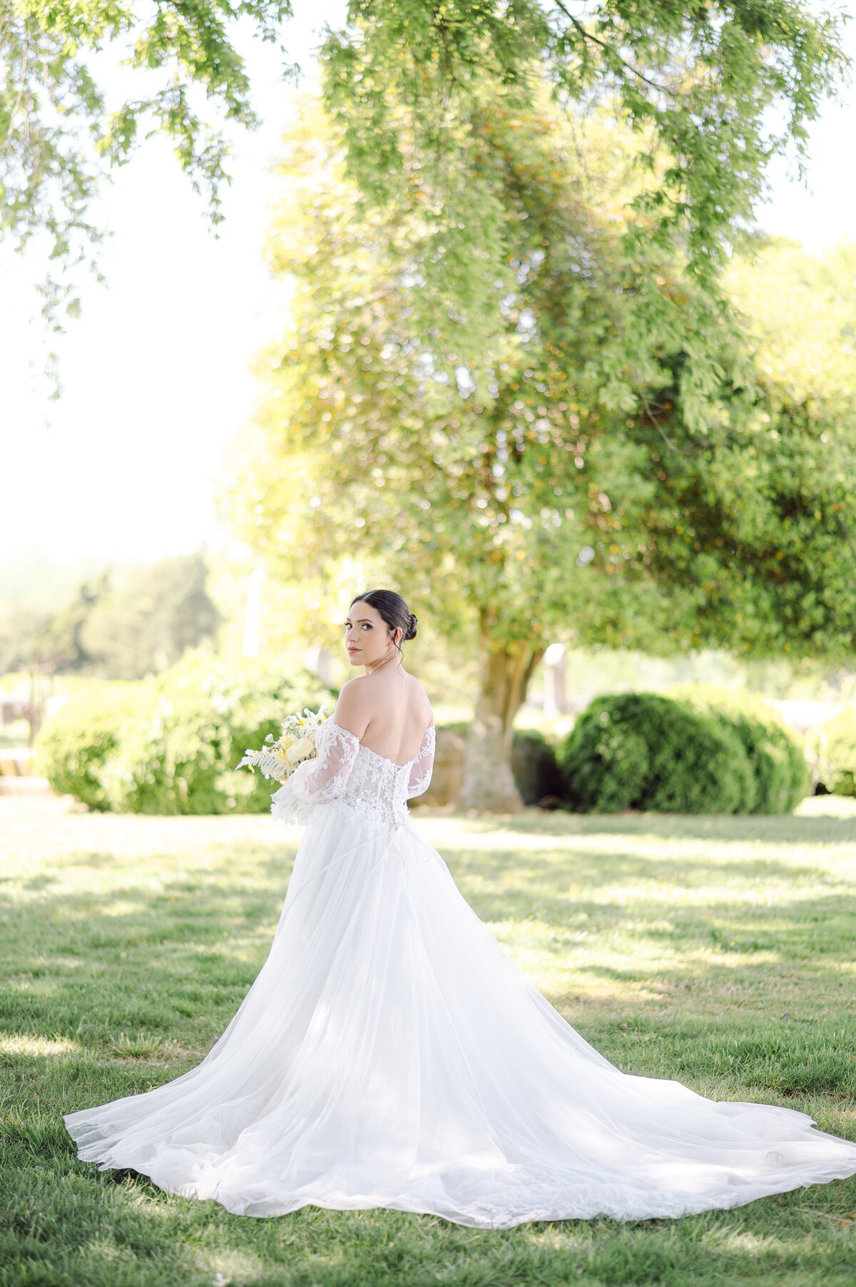 Bride on the lawn beneath the trees