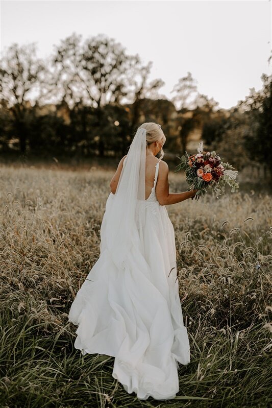 bride walking through a meadow at Silverbrook Farm, Purcellville, VA
