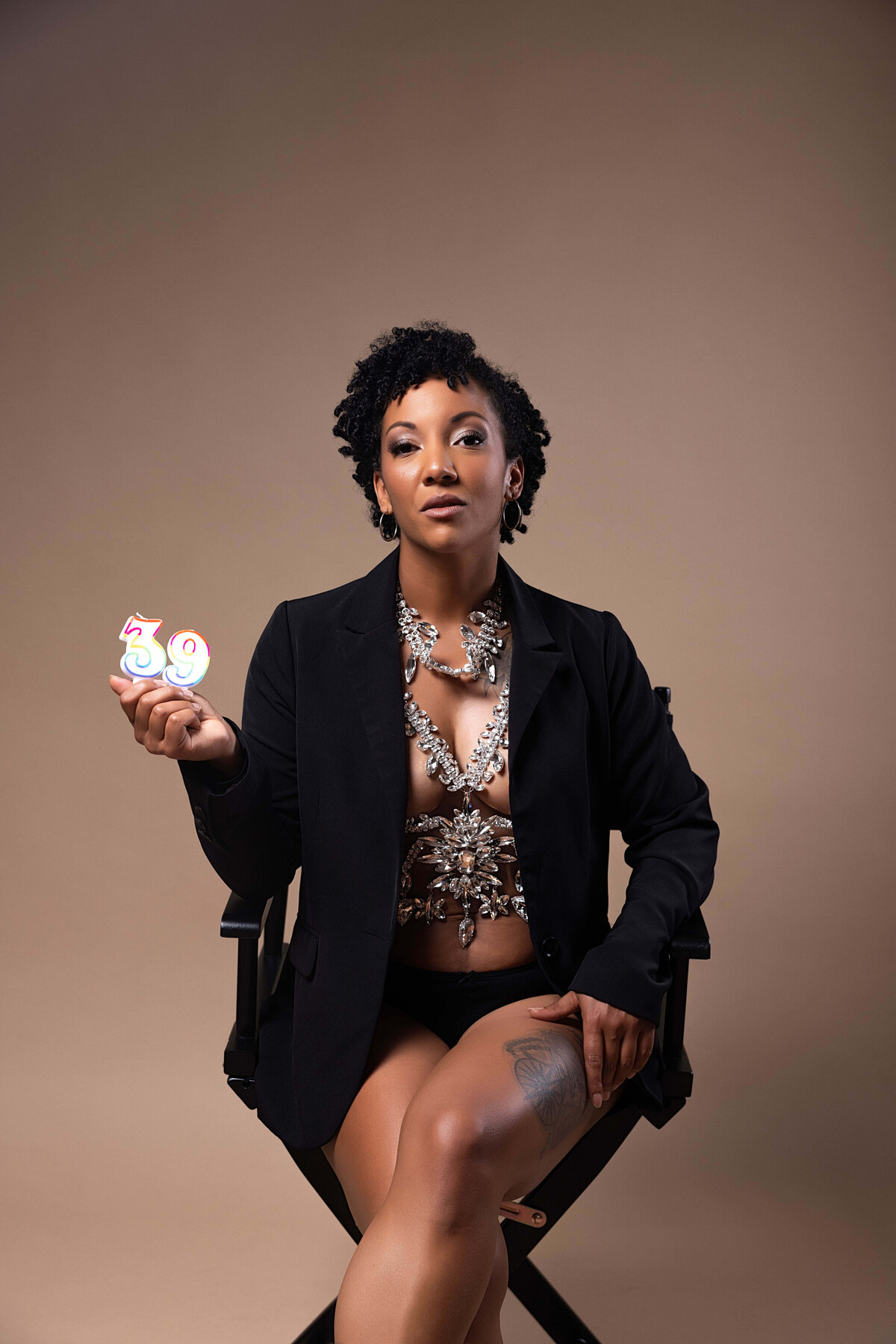 Woman sitting in chair holding 39 candles for birthday session with Reva Davis photography