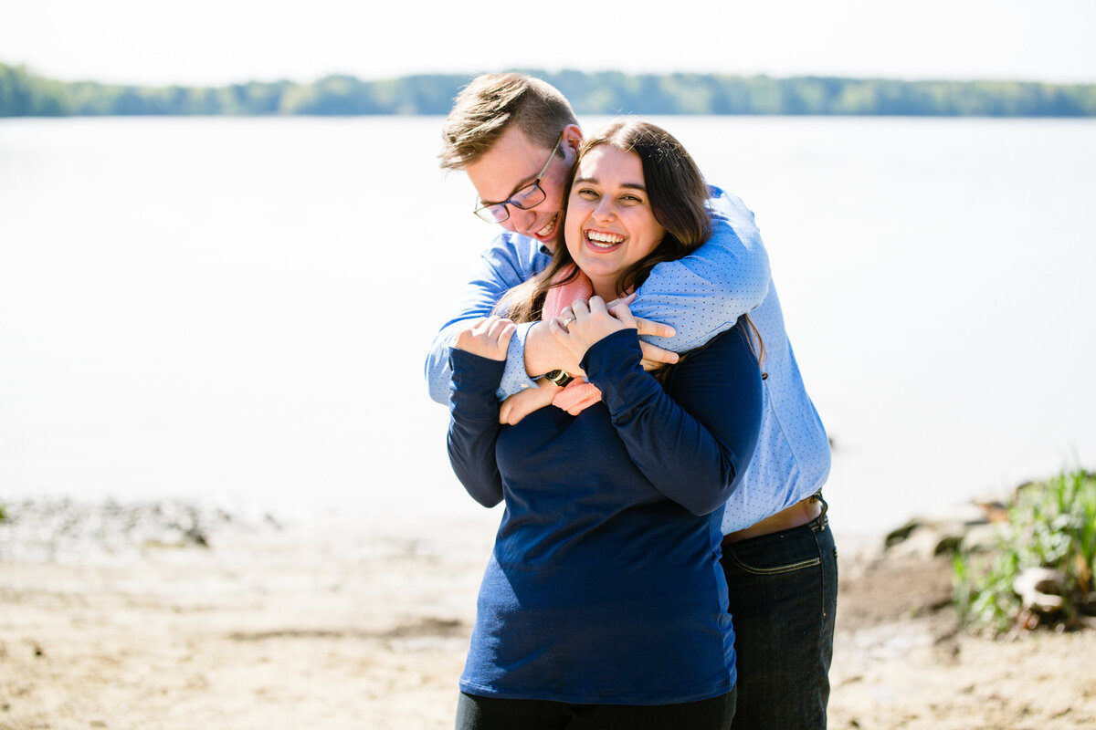 New Hampshire engagement hugging at shore