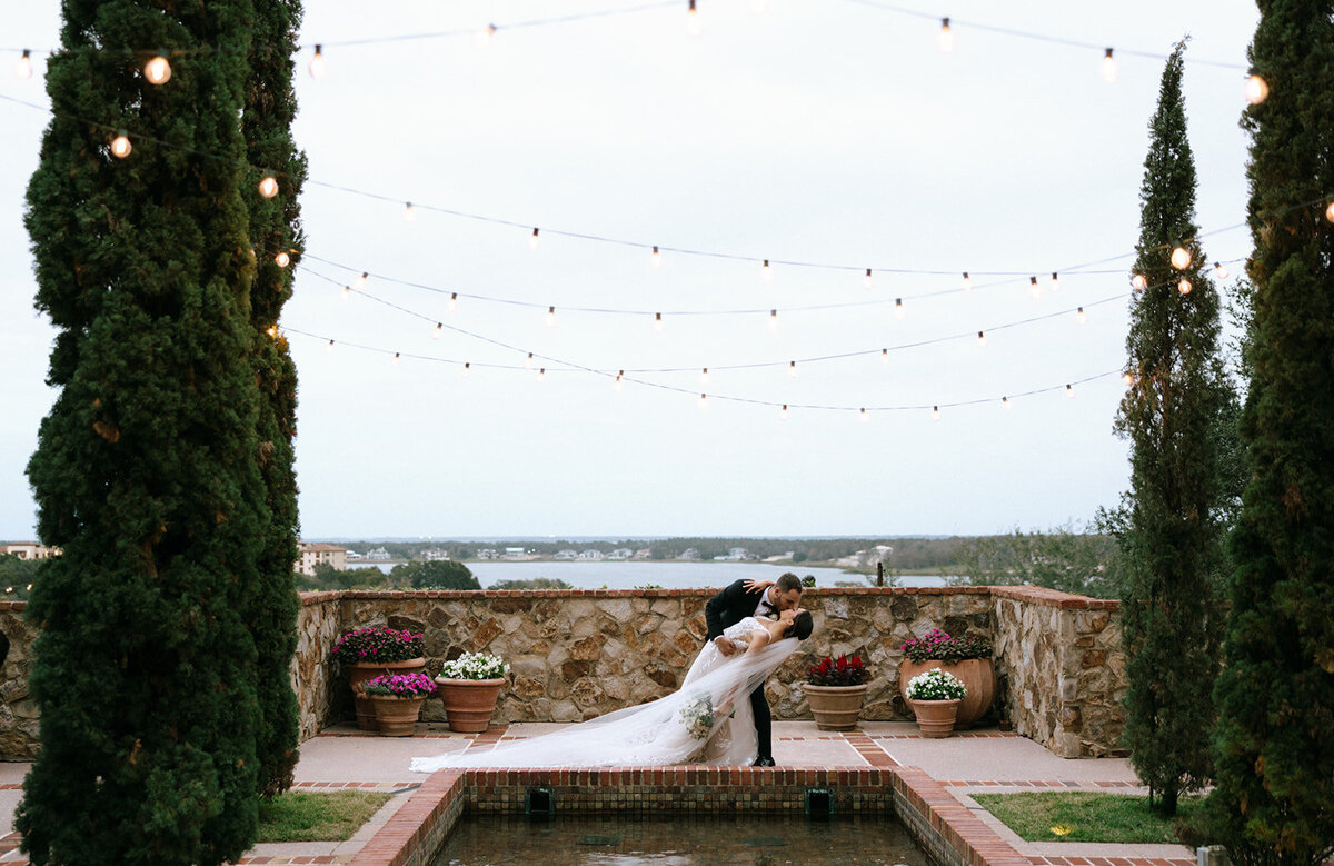 bride and groom dipping and kissing at bella collina wedding photos​