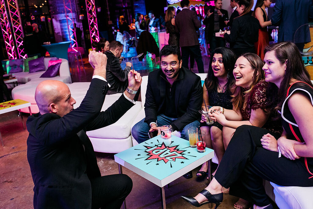 People sit on a couch with drinks, all deep in conversation.