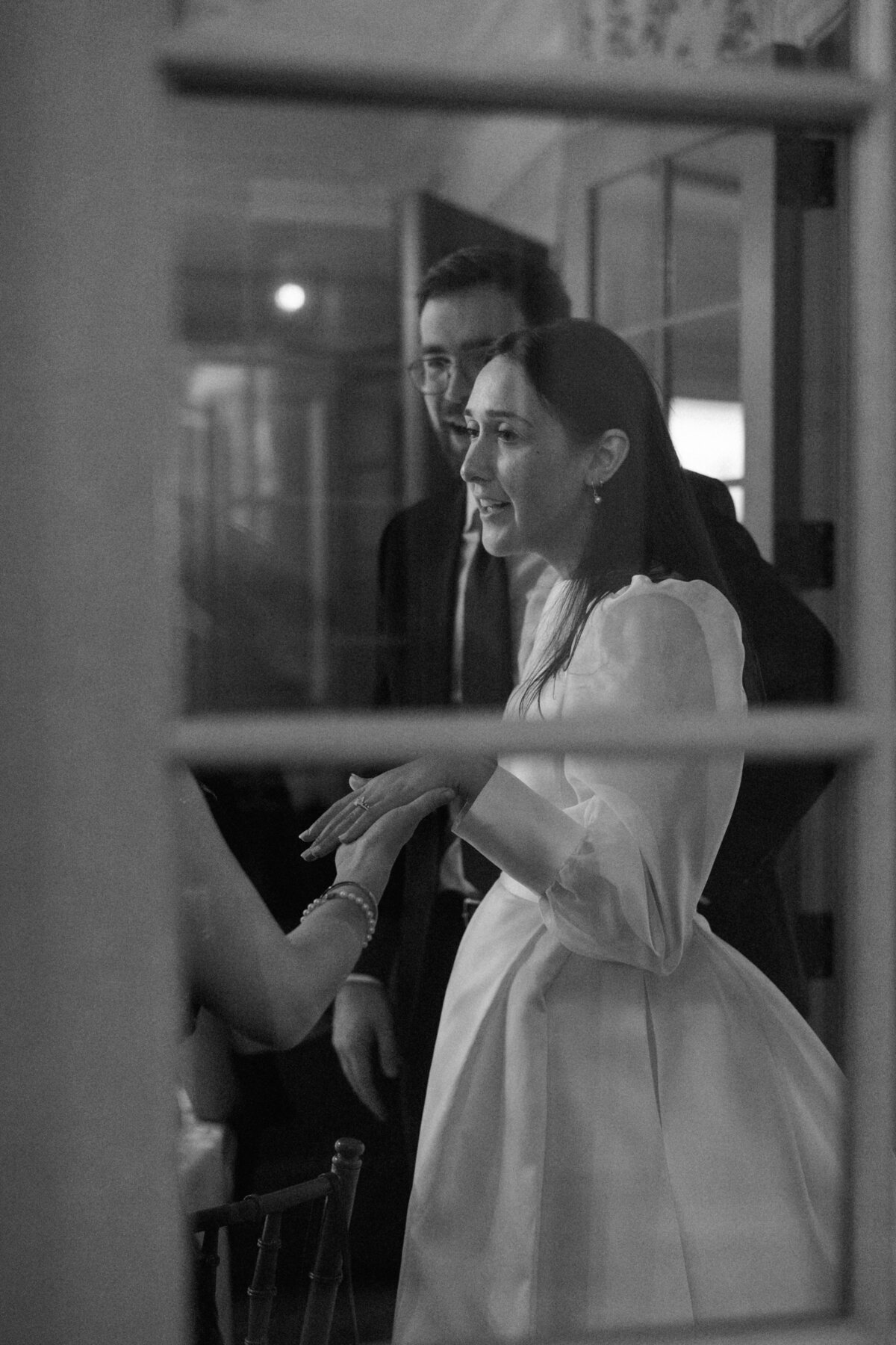 Bride speaking with guests in candid black and white photo at Cleveland wedding.