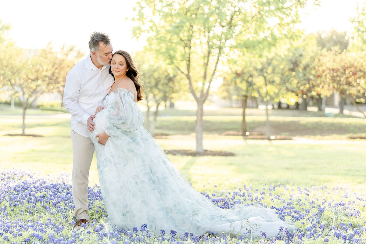 husband and wife nuzzling for maternity shoot