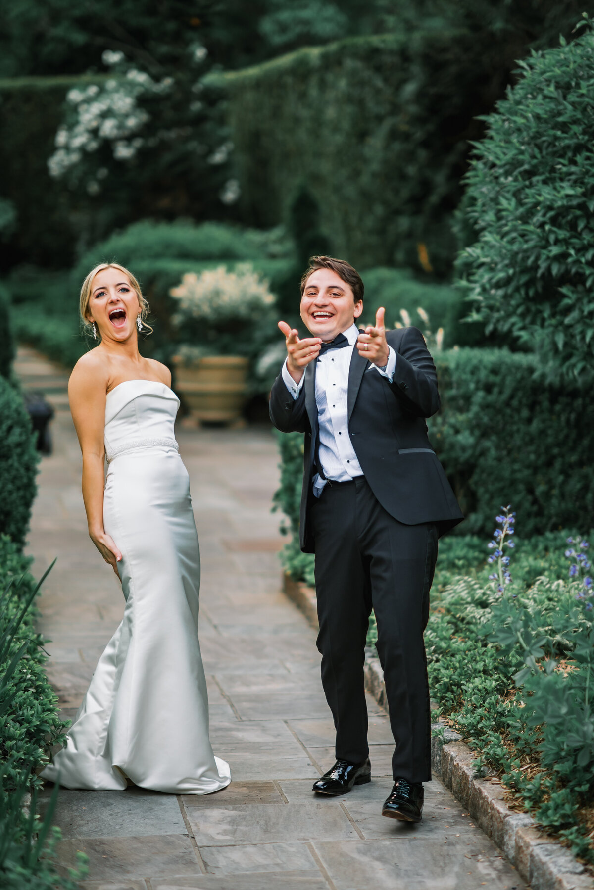 Bride and groom laughing and celebrating during garden portraits at Old Edwards Inn in Highlands, North Carolina.