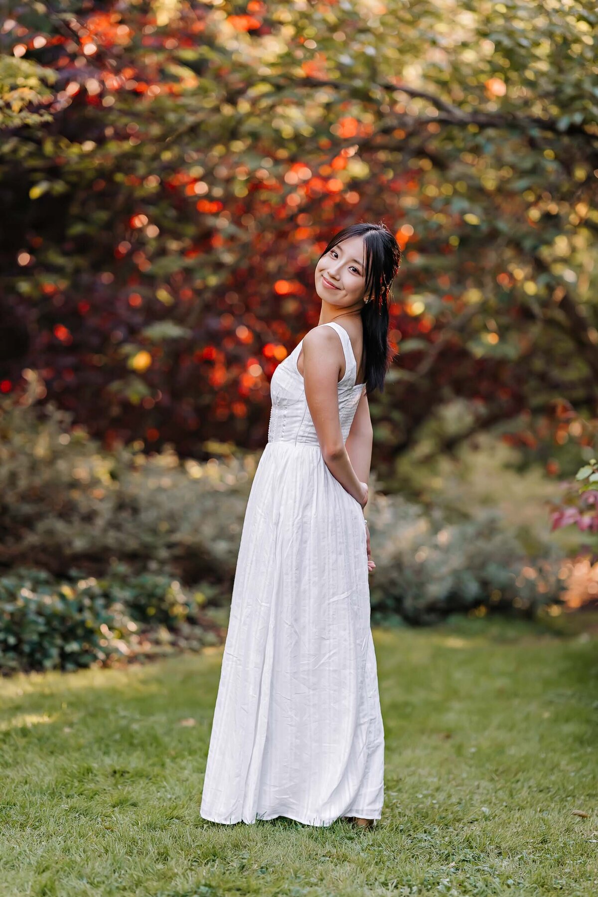 Senior girl turning back to look at the camera, striking a confident and elegant pose during her portrait session.