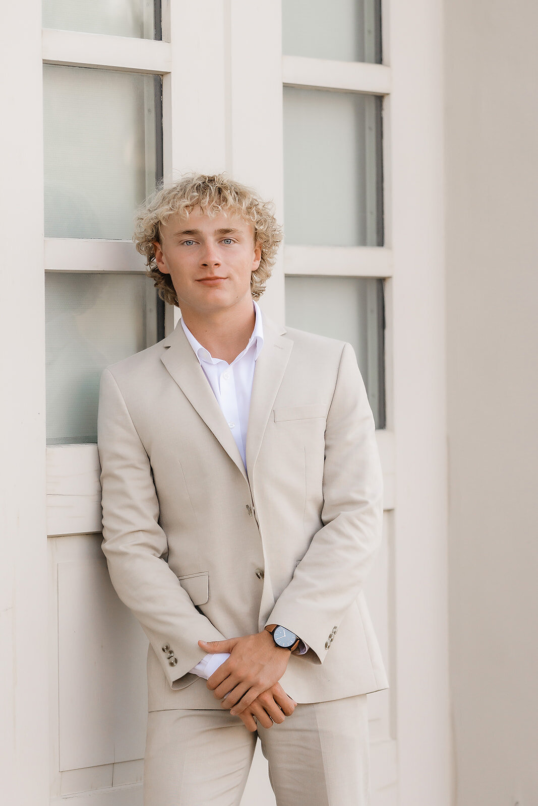Senior boy in suit leaning against wall Topeka