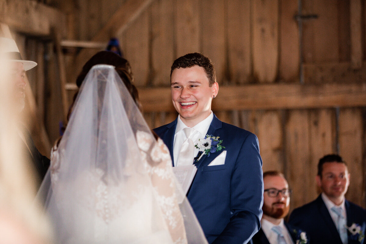 Groom smiles with delight as he admires his bride during their ceremony.