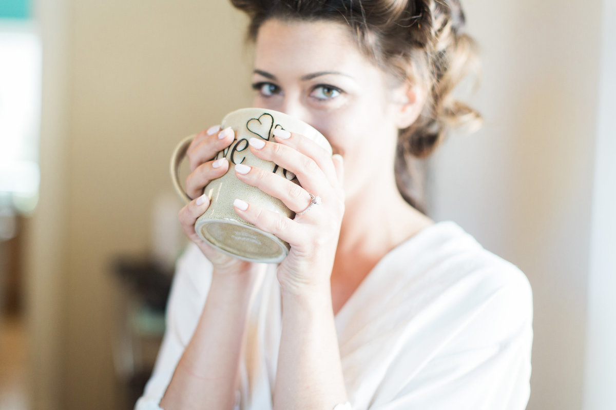 Bride taking a sip of coffee before the wedding  at The Oyster Farm