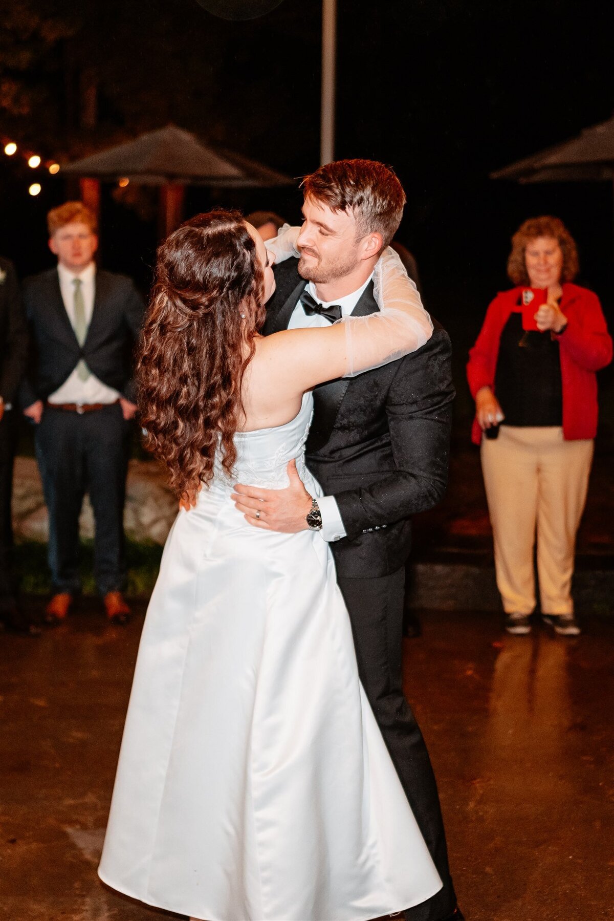 A heartwarming moment captured: a couple swaying together on the dance floor at their wedding reception, enveloped in love and joy.