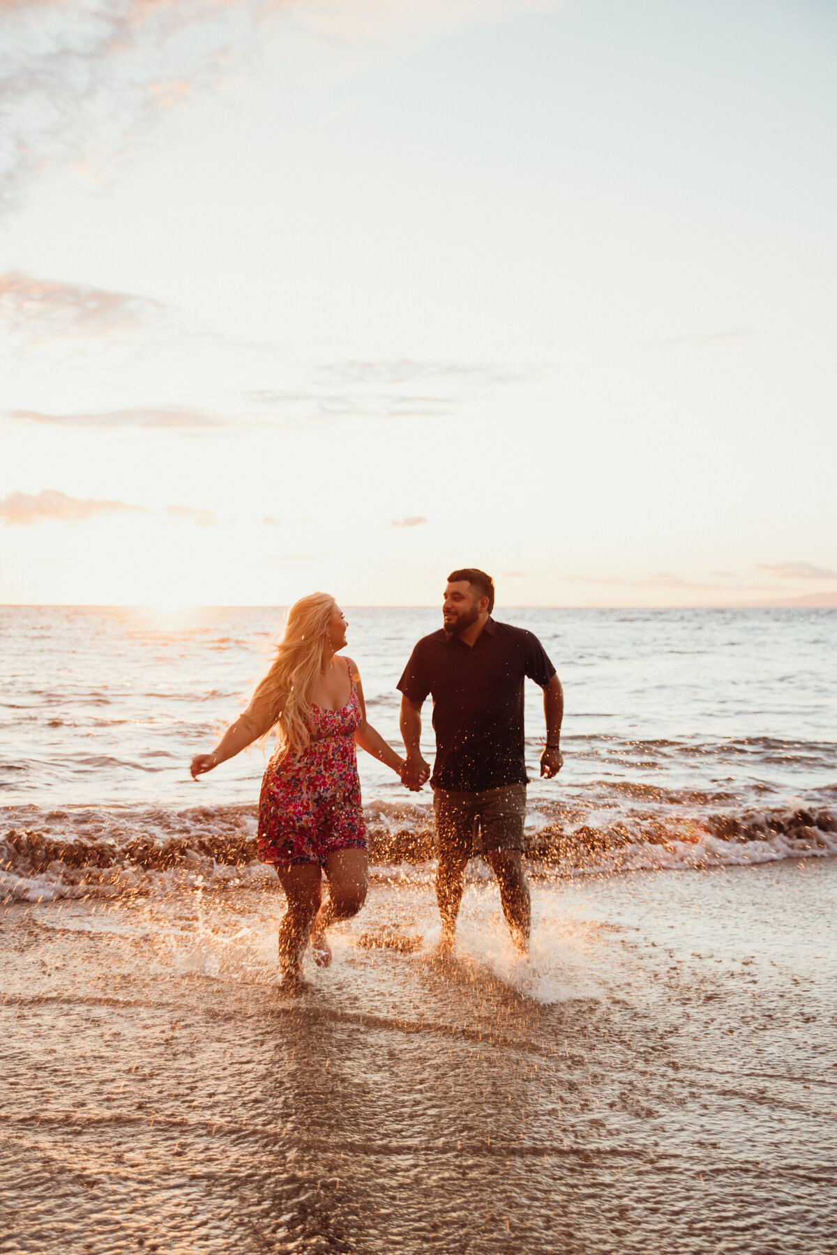 Hawaii Engagement Photographer captures couple running through waves hand in hand