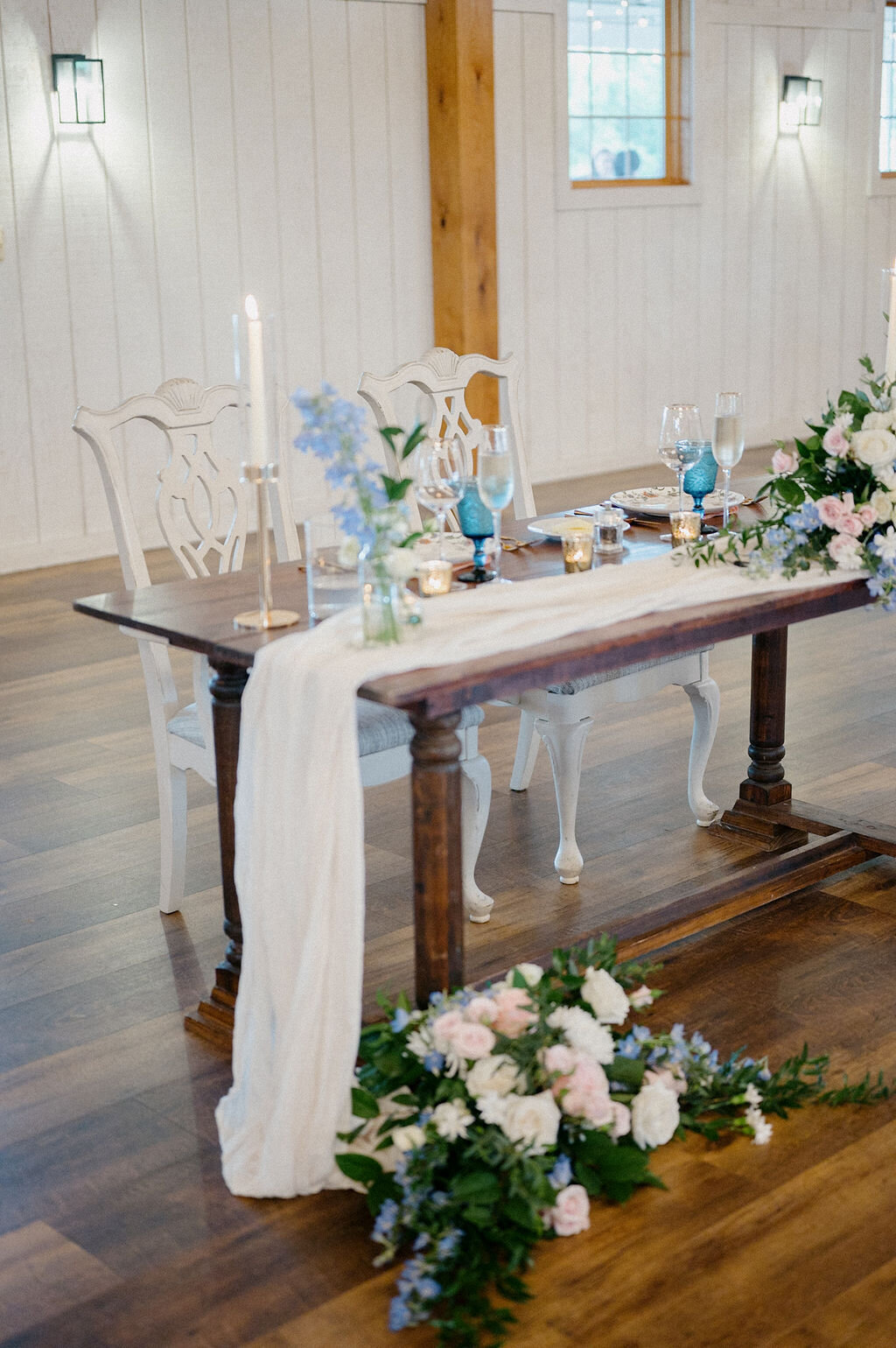 Couples table designed with flowers with blue drinking glass