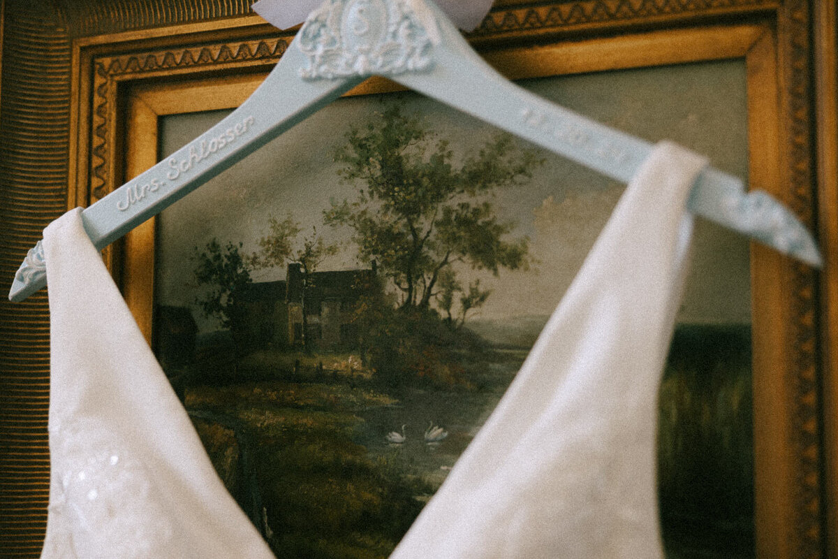 Bride's wedding dress hanging on a personalized hanger in Asheville, NC, captured by Andrea-Marie Photography