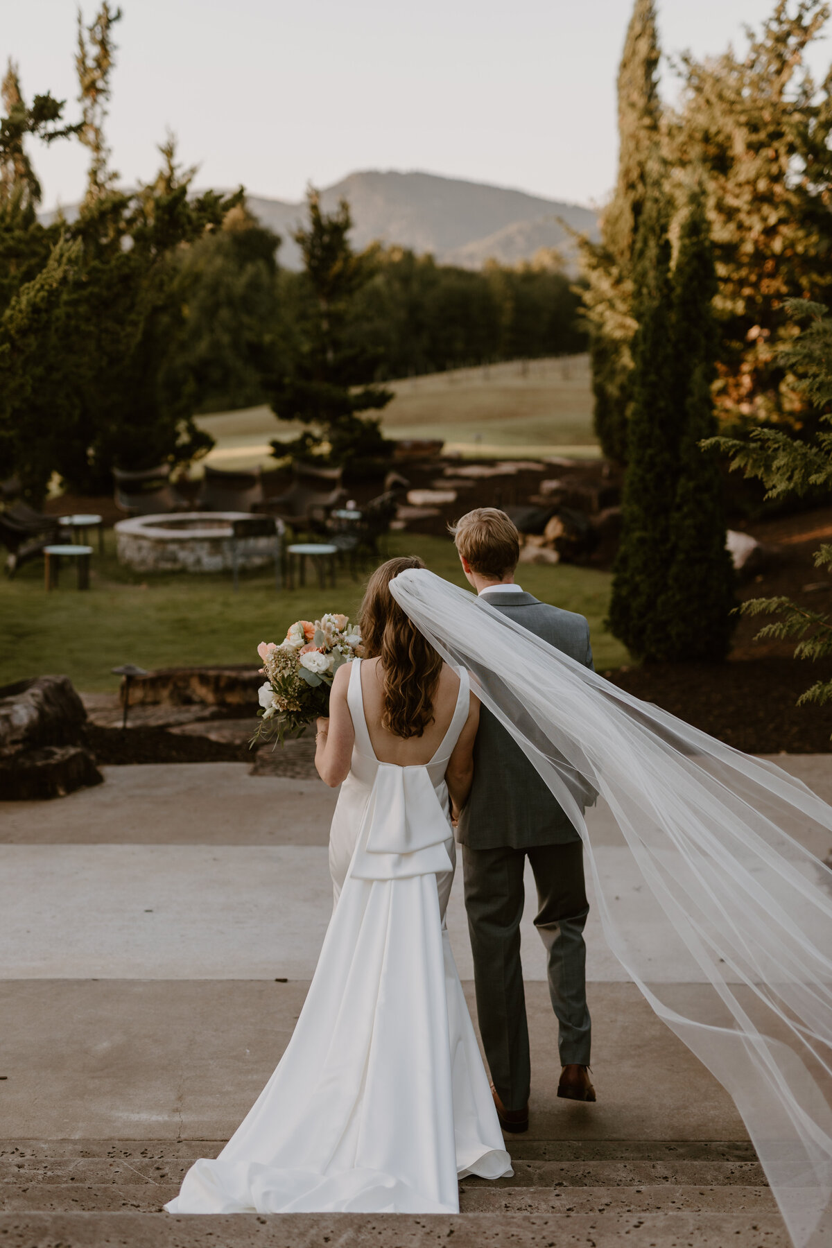 Newlyweds walking hand-in-hand through the romantic, ivy-lined courtyard.