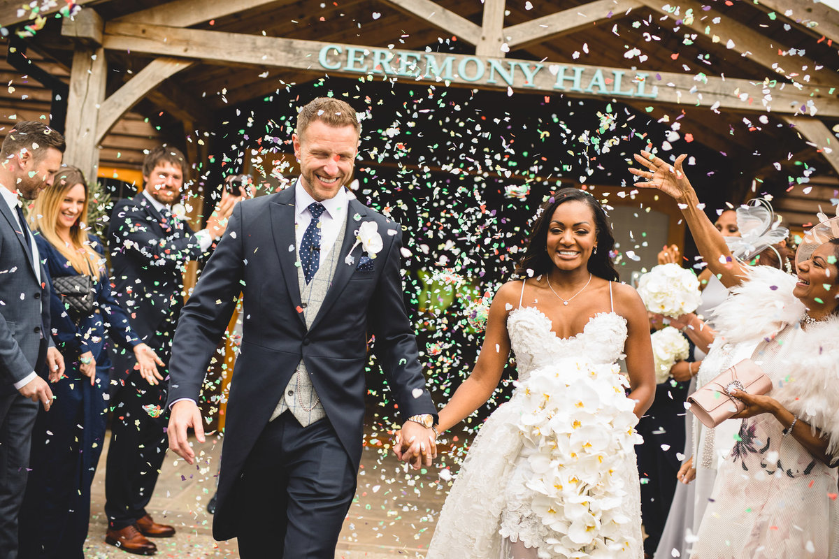 bride and groom having confetti thrown at them after their wedding ceremony