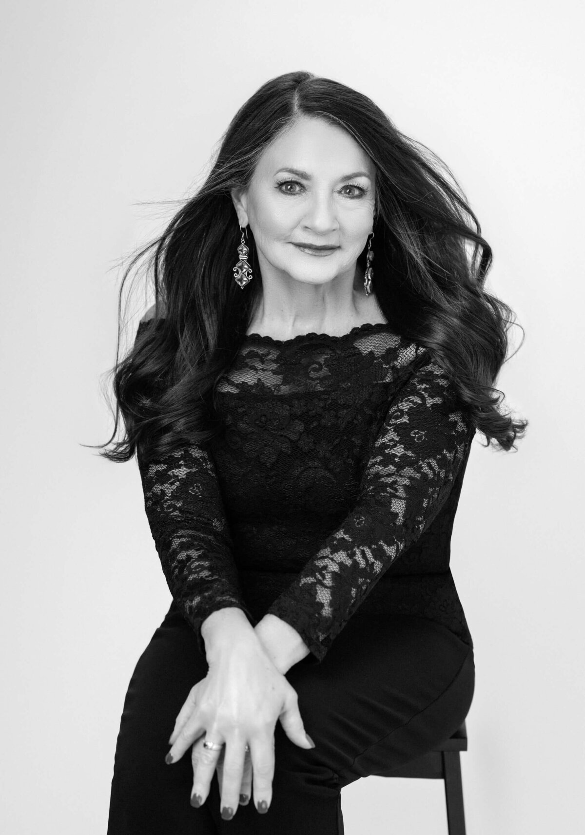 Timeless black-and-white portrait of a woman in a bejeweled dress, sitting elegantly.