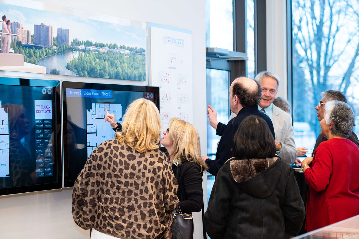 Ottawa event photography showing guests of the eQ groundbreaking event looking at model home plans.  Captured by JEMMAN Photography COMMERCIAL