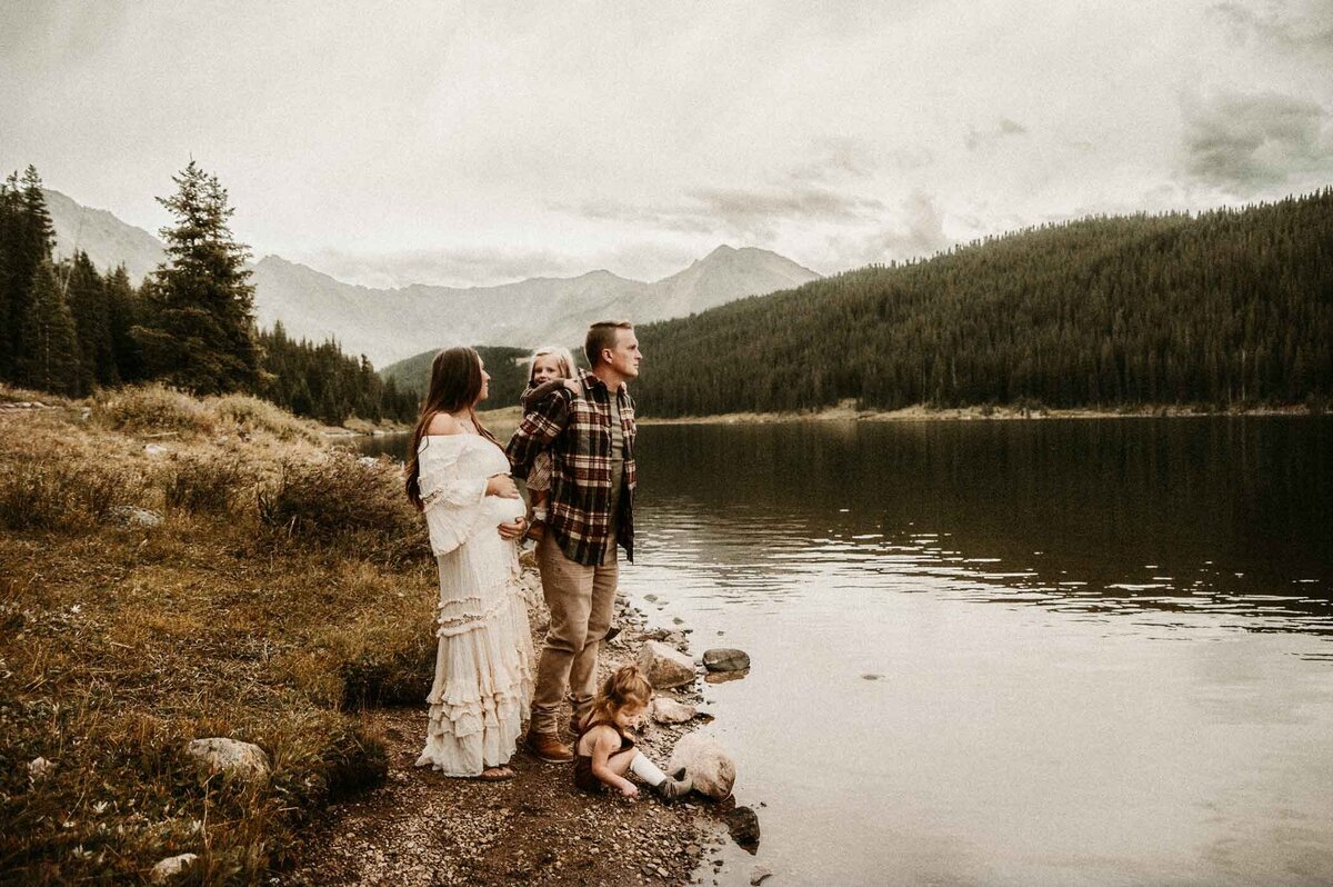 Family-of-four-by-lake-in-Colorado-mountains-outdoor-moody-family-maternity-session-Missouri-lifestyle-photographer