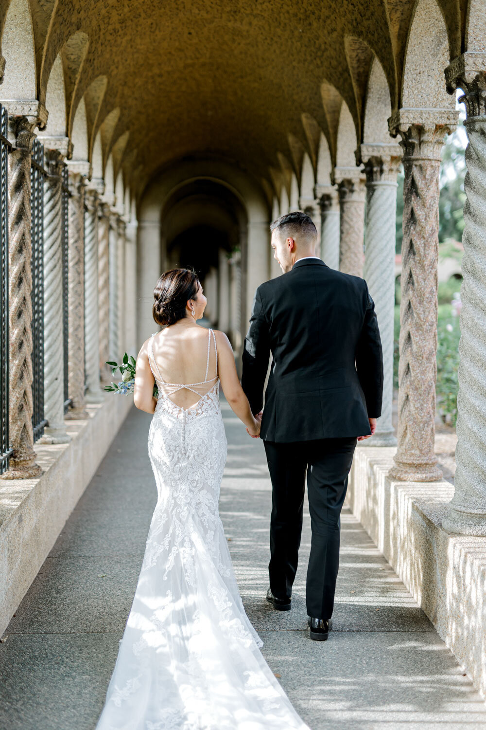 Bride and groom hold hands while walking