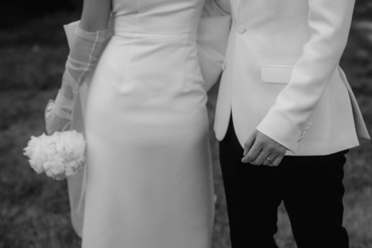 Das Paar steht nebeneinander, die Braut hält ihren Strauß seitlich locker in der Hand.