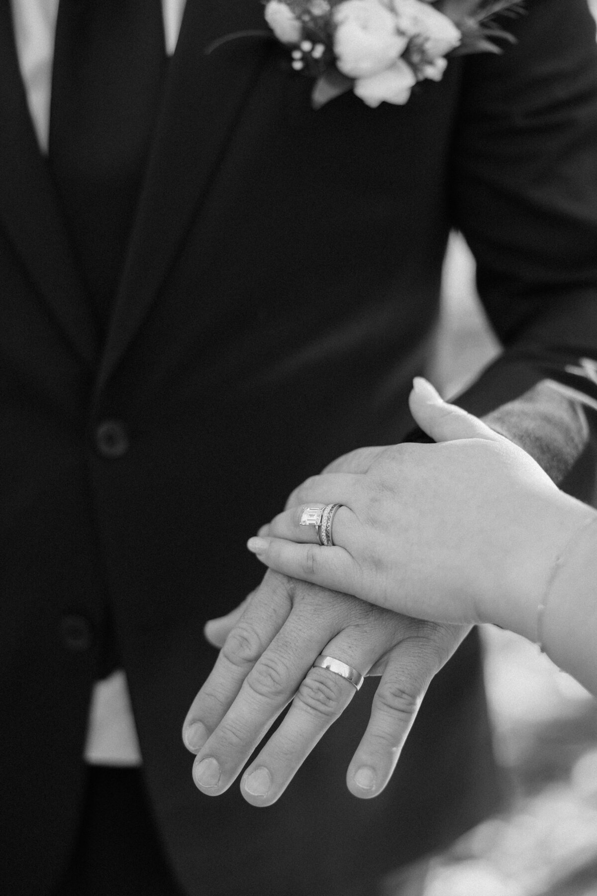 The bride and groom showing off their wedding rings.