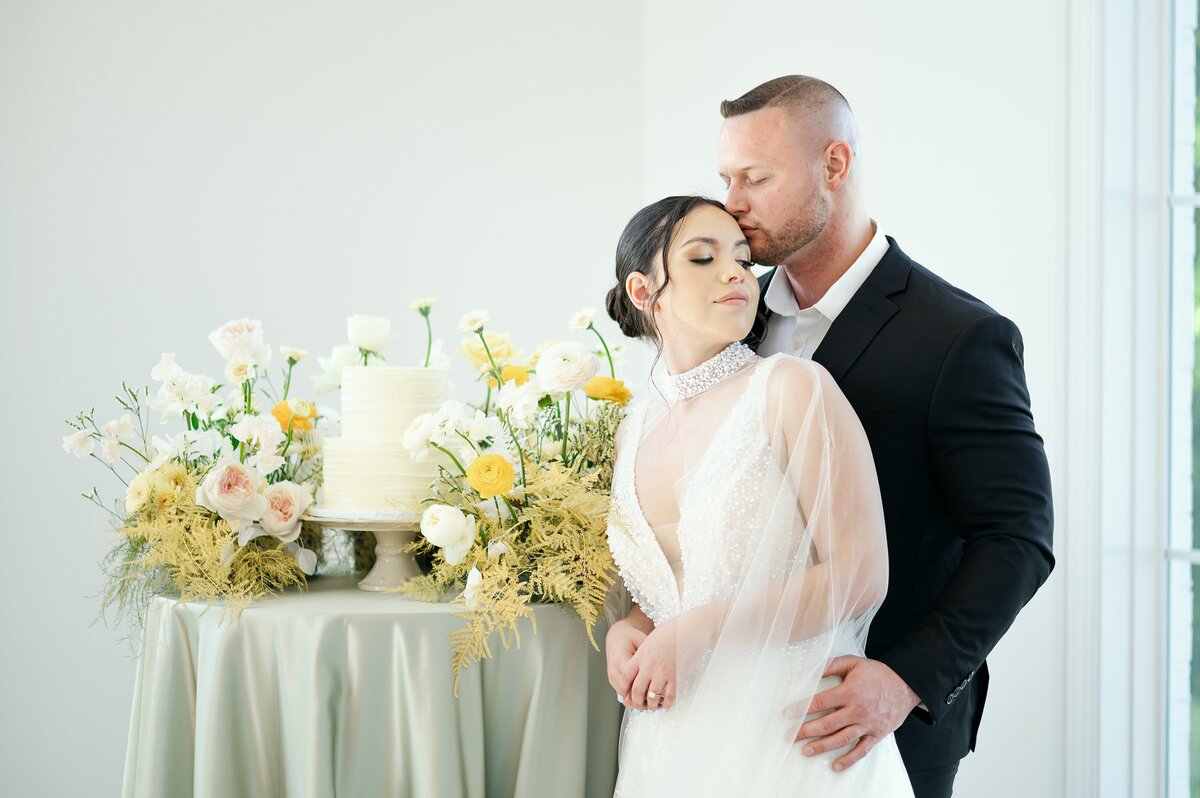Couple beside the cake table in the ballroom
