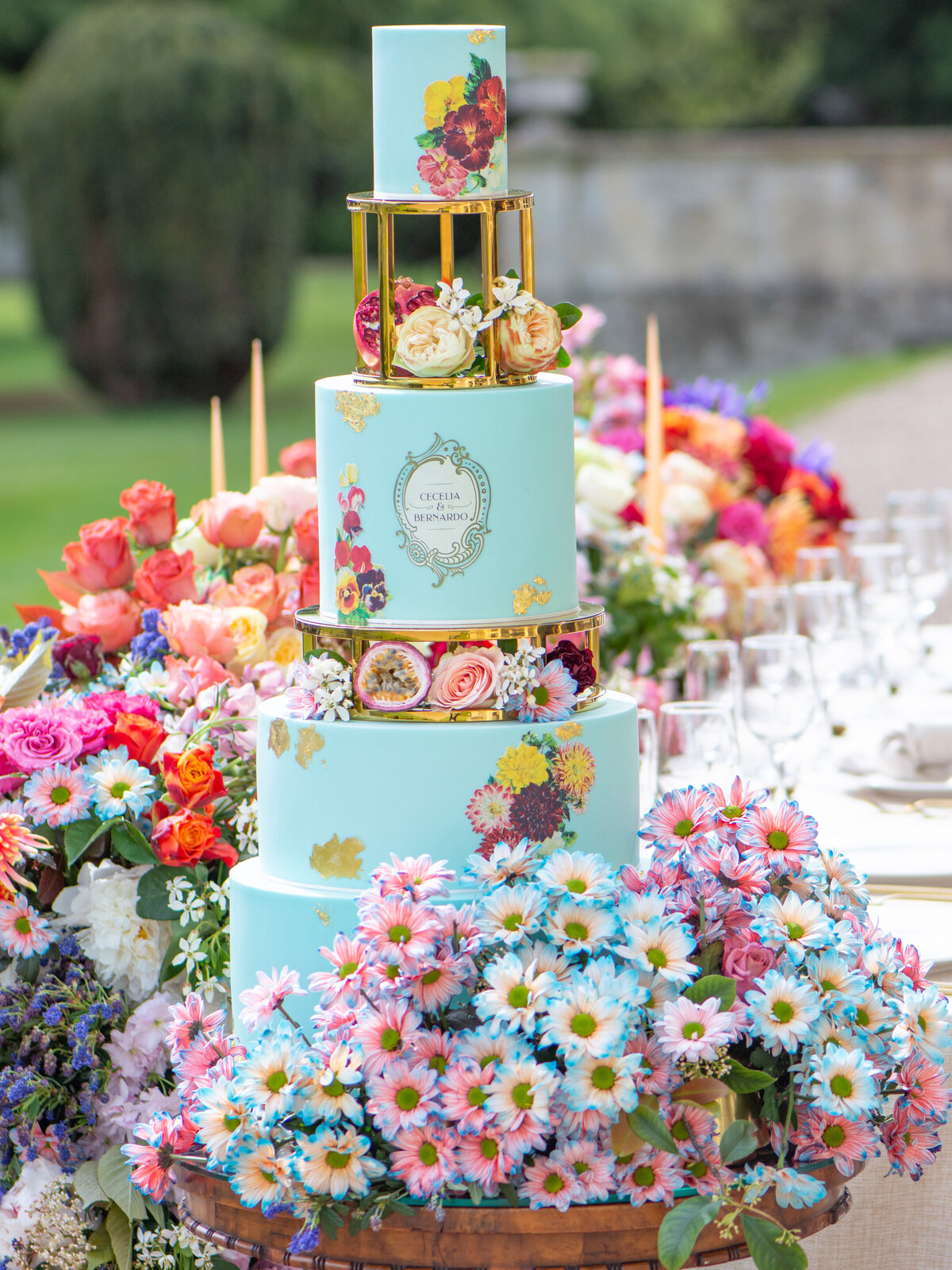 Baby blue wedding cake with bold florals at outdoor wedding at Prestwold Hall