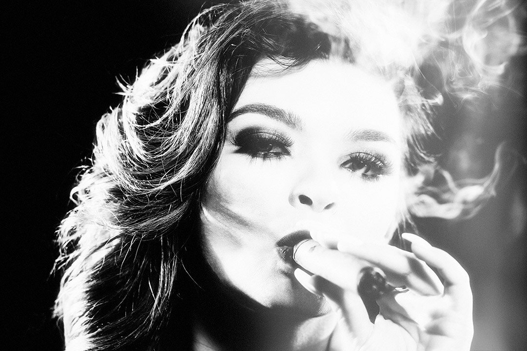 A gorgeous black and white image of a woman smoking a cigar with Old Hollywood Glam lighting.