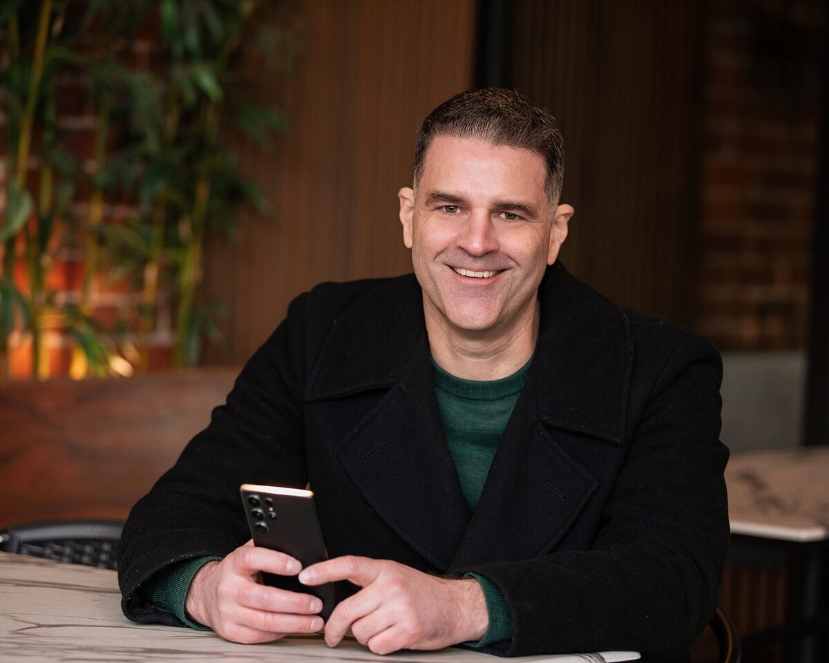 man with phone sitting at table