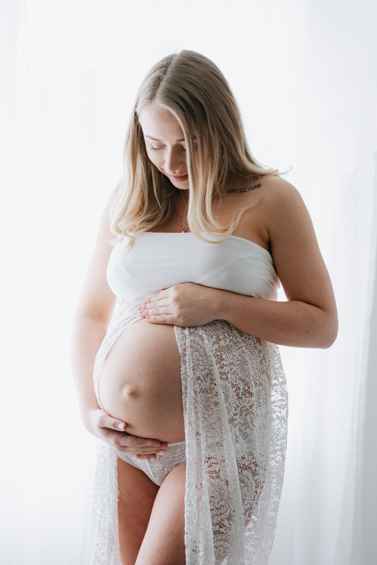 Mum holding pregnant bump at maternity photoshoot in Billingshurst