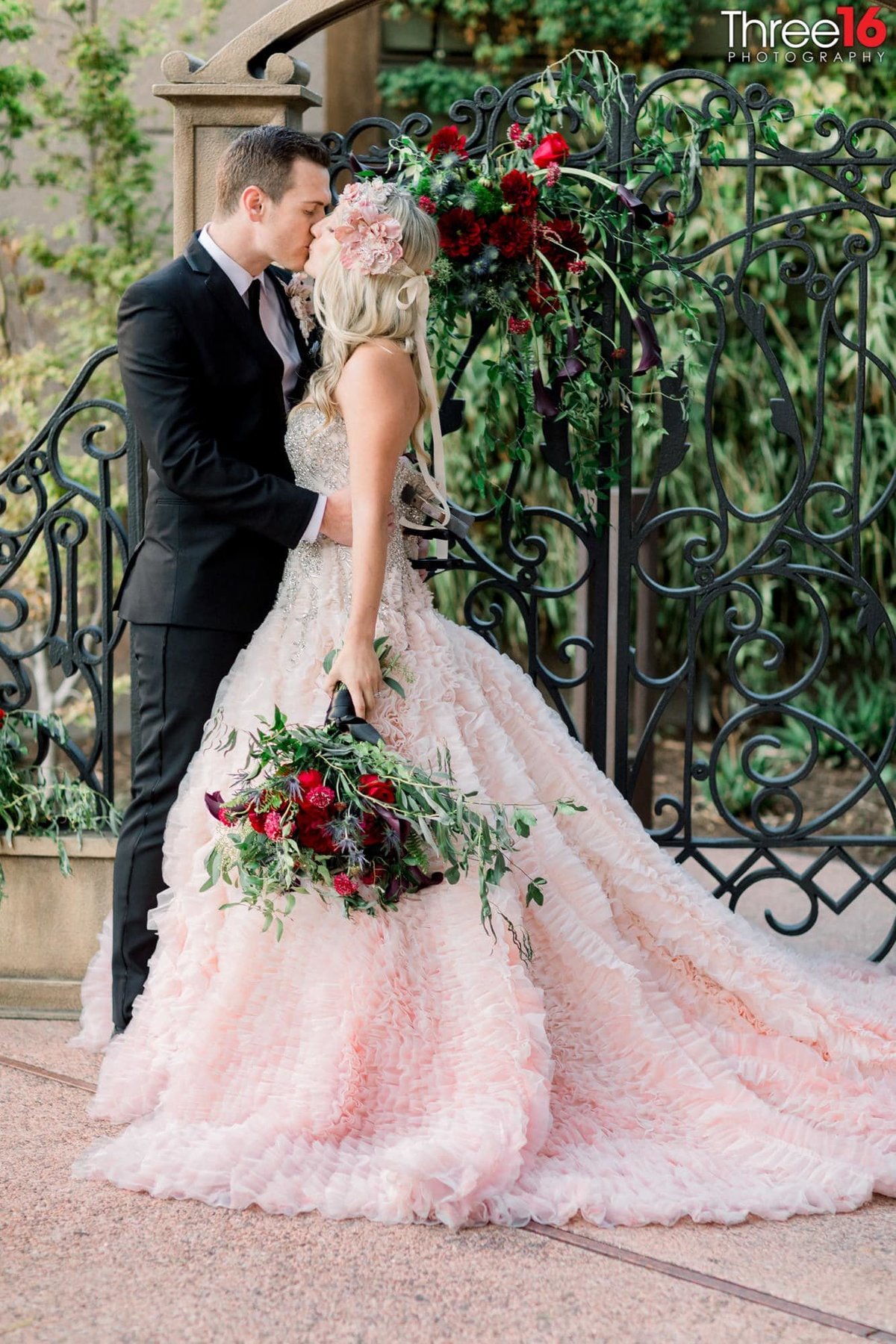 Bride and Groom share a tender kiss outside during a photo shoot