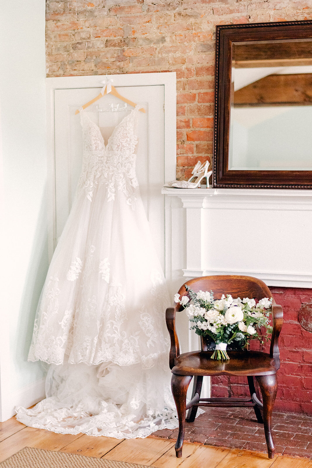 bride's dress hanging with bouquet and shoes