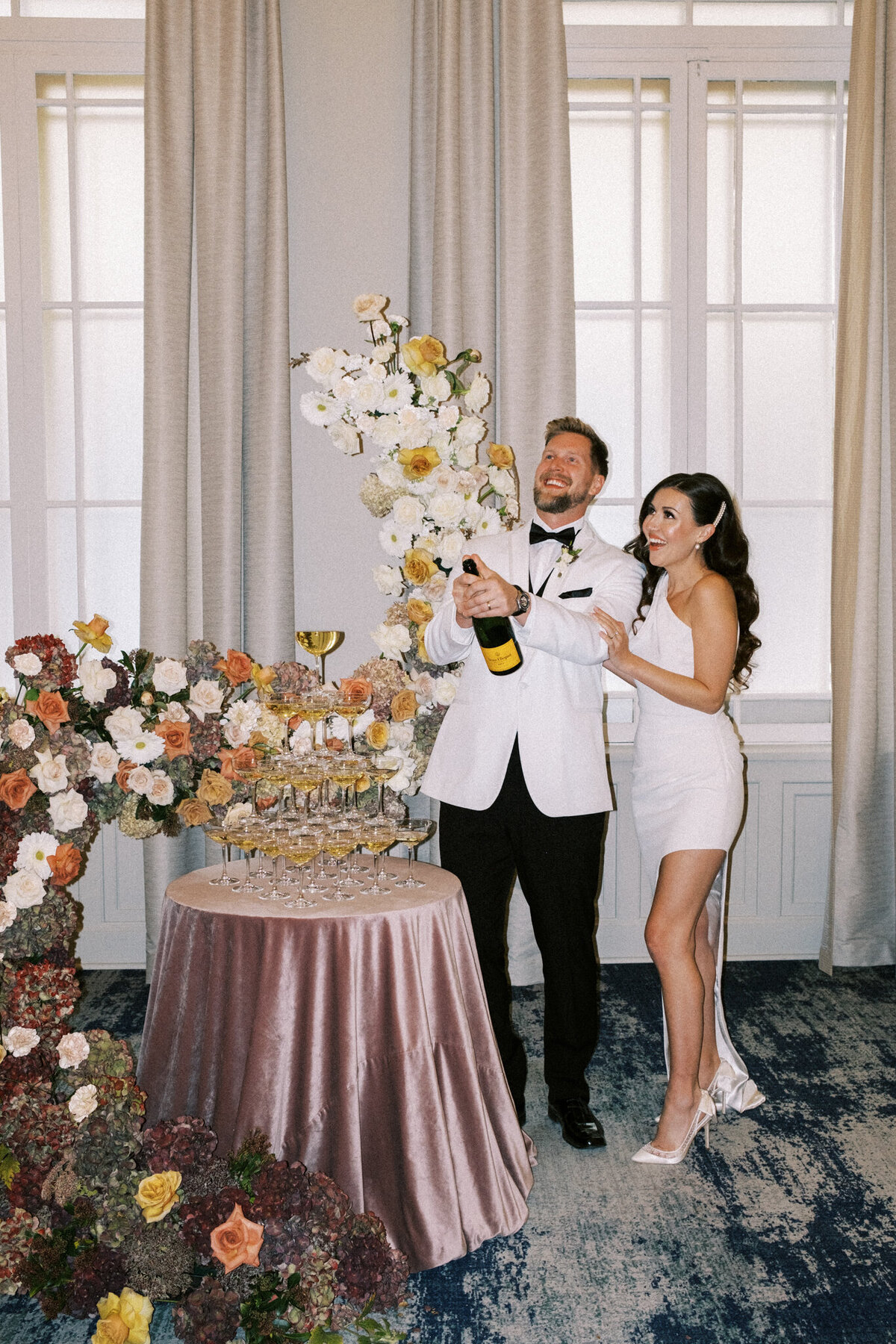 Trendy bride and groom popping champagne at the Fairmont Palliser, featured on the Bronte Bride Vendor Guide.