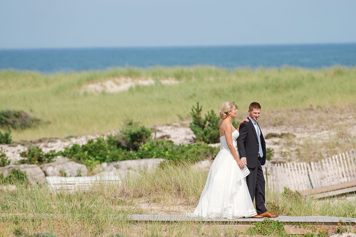 Bride and groom walking on the boradwalk at Oceanbleu Beachfront Catering