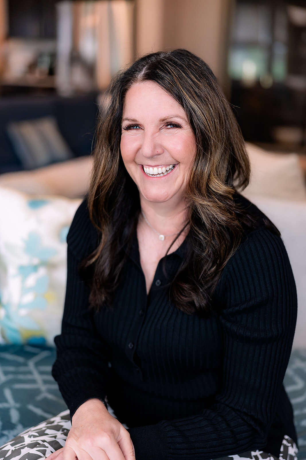 Woman smiling at the camera in a black long-sleeved shirt