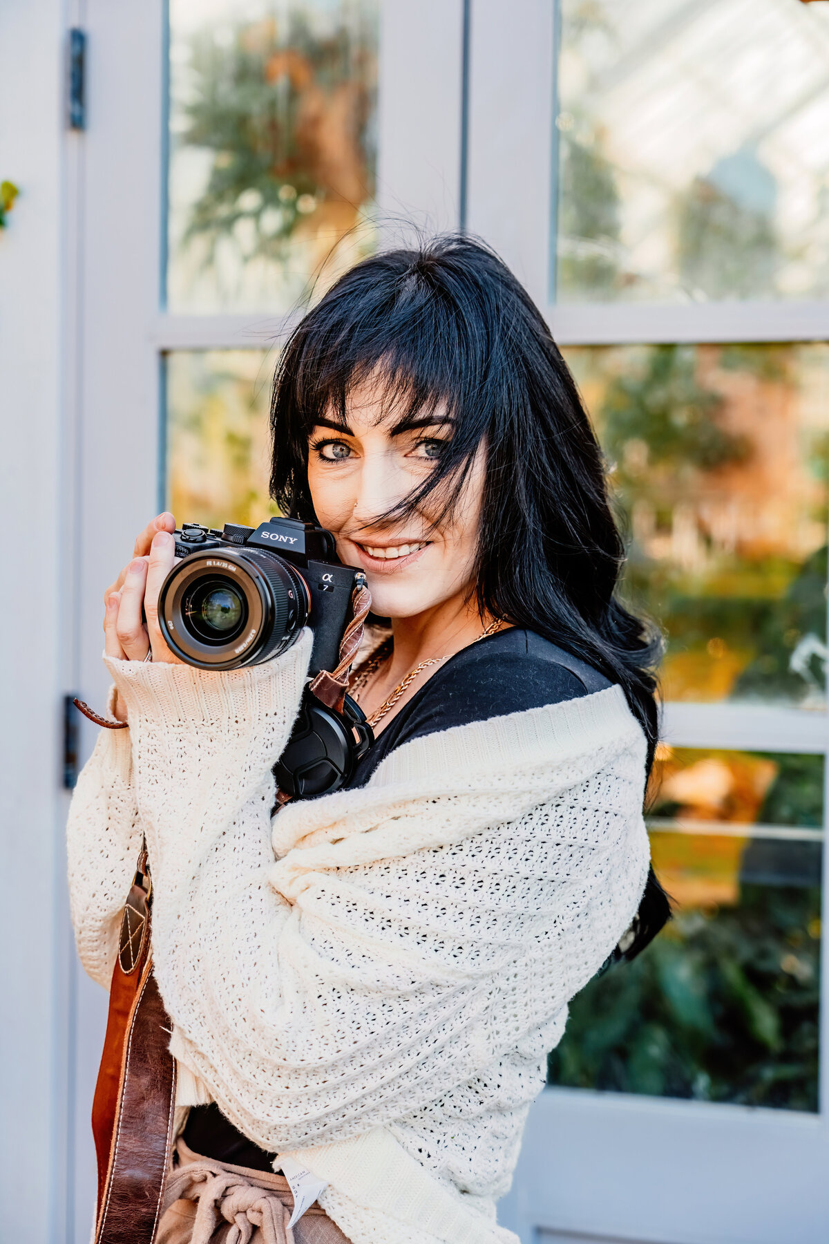 a close headshot of a photographer in front of a botanical garden