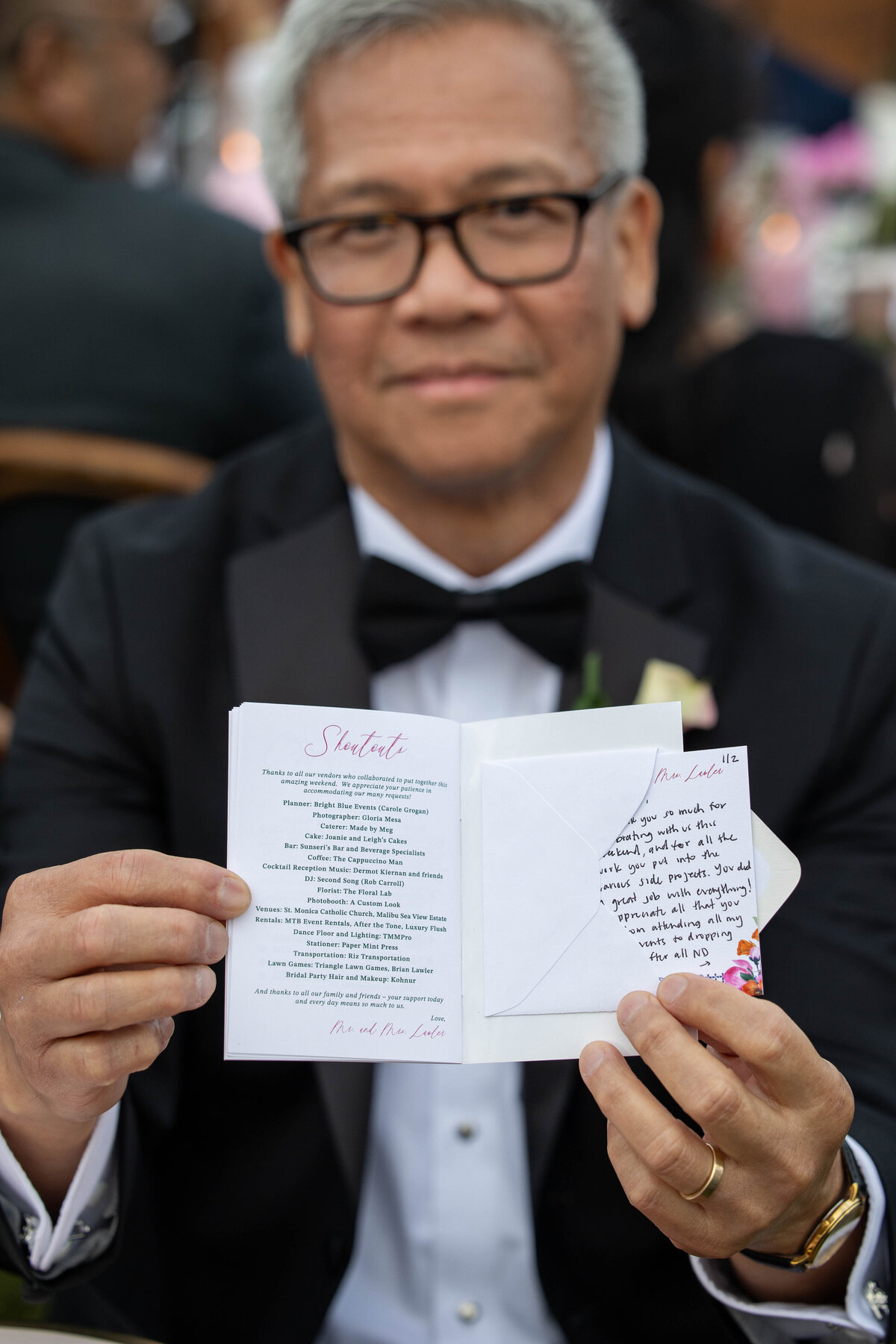 Older Filipino male holding a card