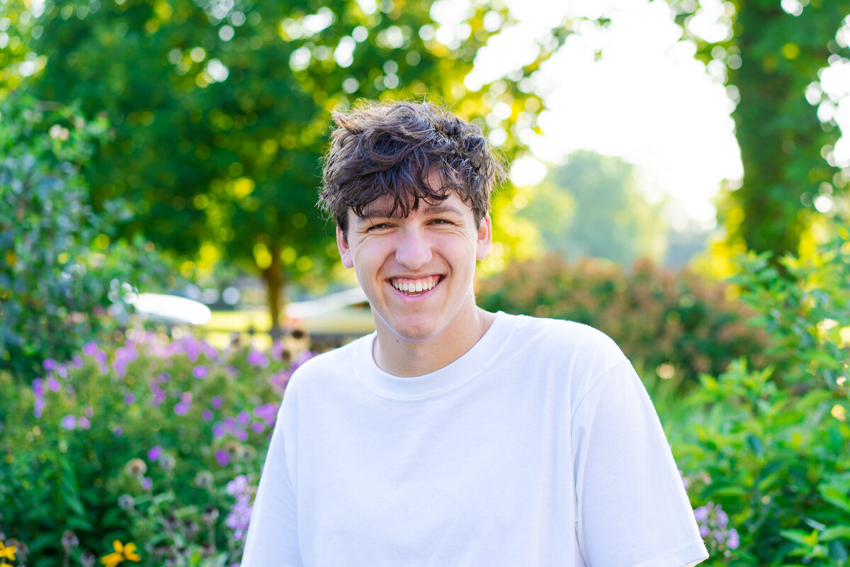 High school senior, Nic Allen, laughs at the camera in front of flowers at the Franklin Park Conservatory in Columbus Ohio.