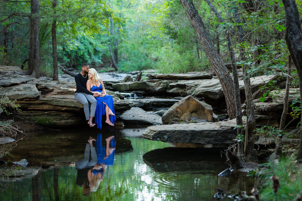 Couple snuggling on rocks at stone creek park in flower mound texas