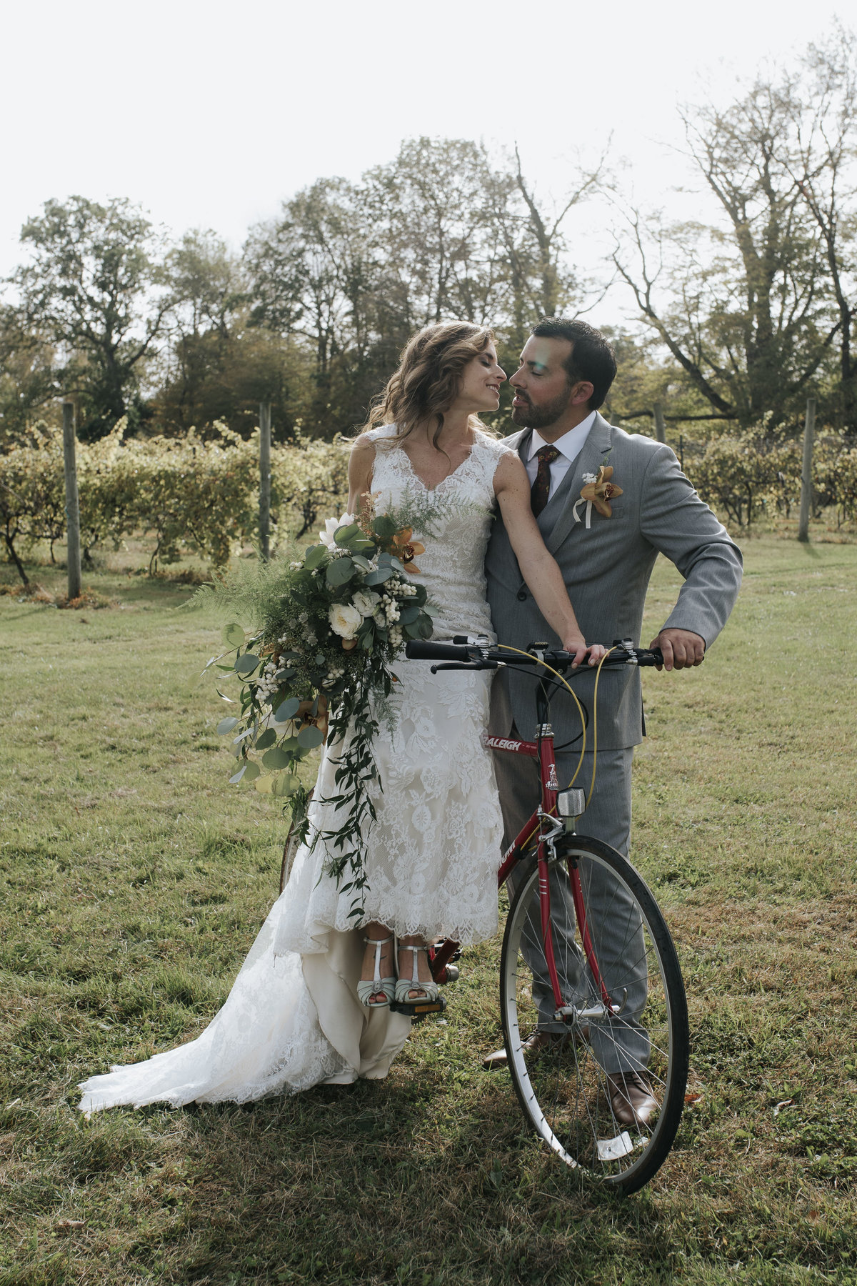 Couple on bicycle after vineyard wedding