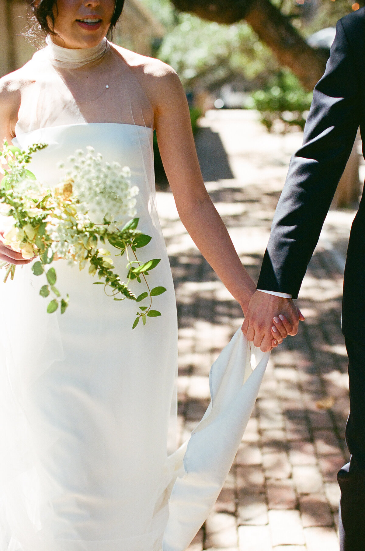 Bride and groom holding hands in the grounds of Mattie's wedding venue in Austin