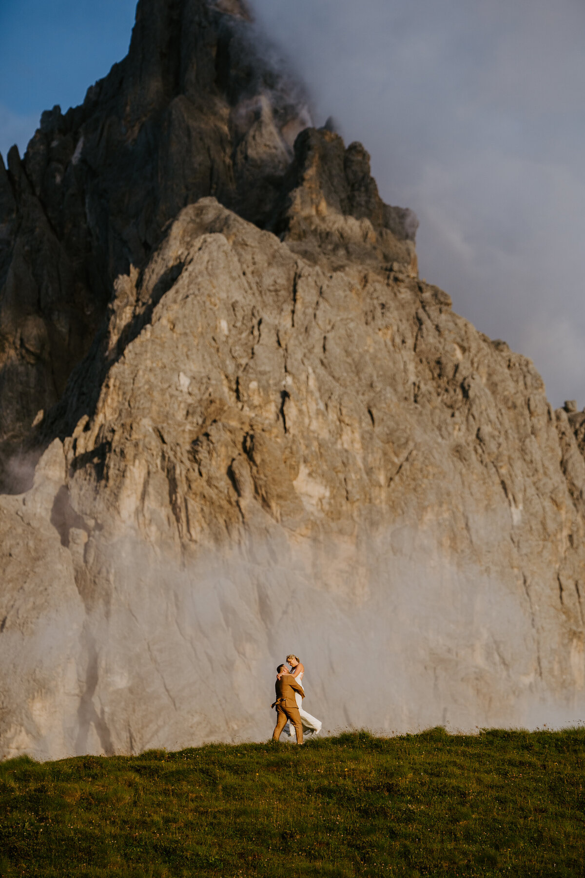 Dramatic Dolomites cliffs with low clouds at sunset