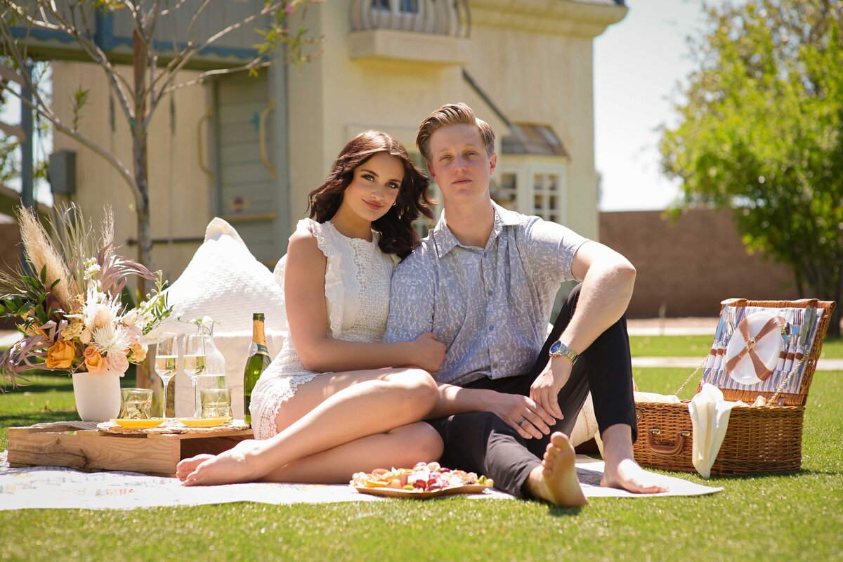 Man and woman pose for a portrait at their picnic proposal