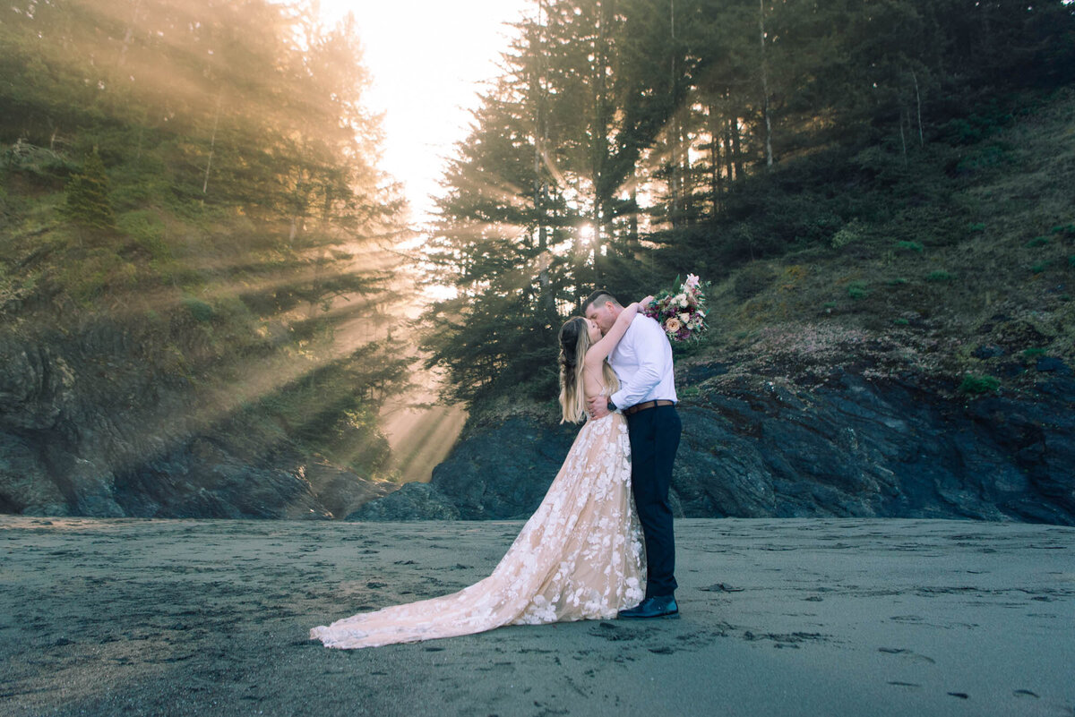 Arms around grooms neck sun rays elope