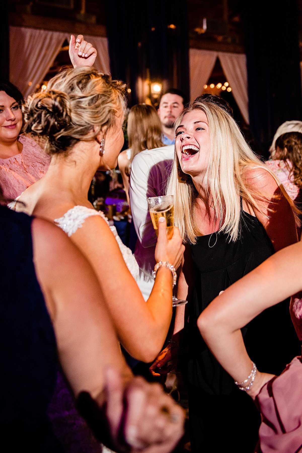 Bride and friend dancing and laughing together