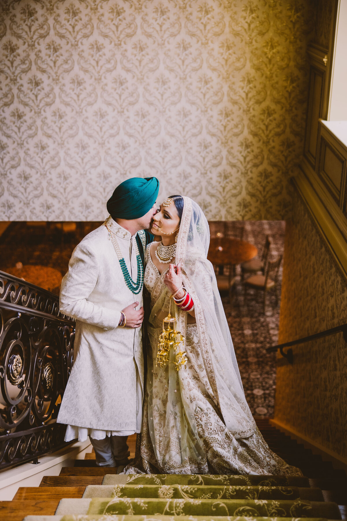 indian sikh bride and groom share a moment at the top of the stairs inside the brigalias nj during the wedding