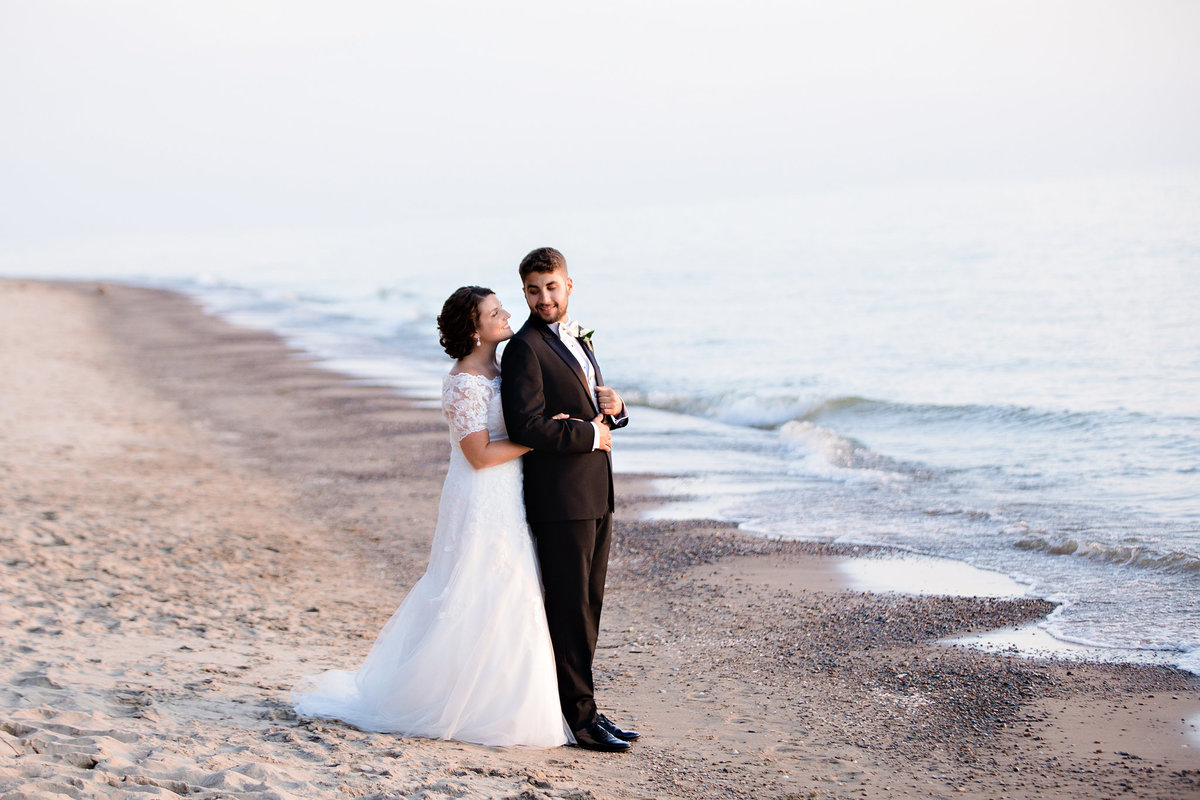 Bride and groom on the shore of Lake Michigan in Saugatuck.